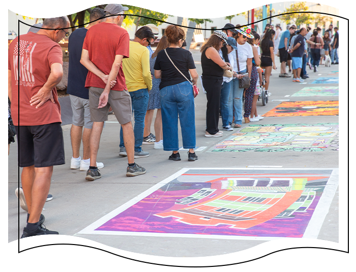 People standing and drawing at chalk the block